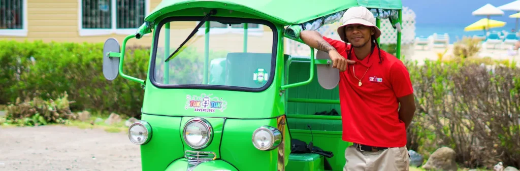 staff standing next to green tuk tuk rock adventures antigua