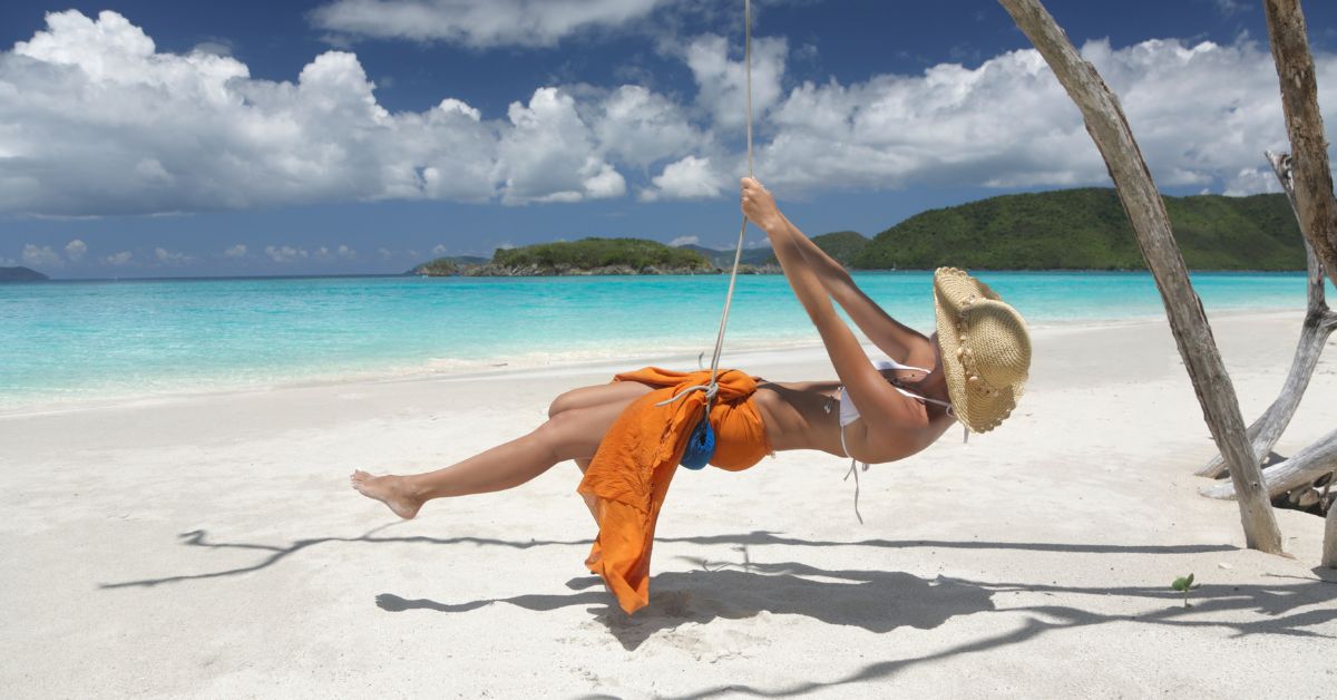 woman swinging on beautiful beach in the carribean Top 10 Things To Do in Antigua feat