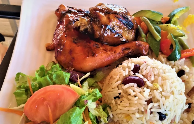 Tasty jerk chicken, salad and rice with beans in Antigua in the Caribbean Best 2024 Antigua Food Guide rockadventures body