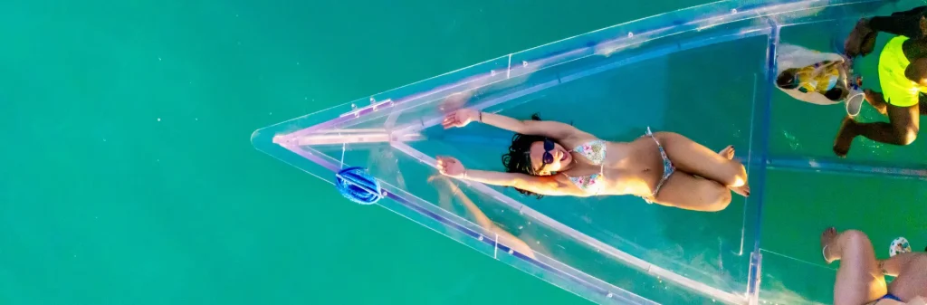 happy girl laying on glass boat rock adventures antigua tour